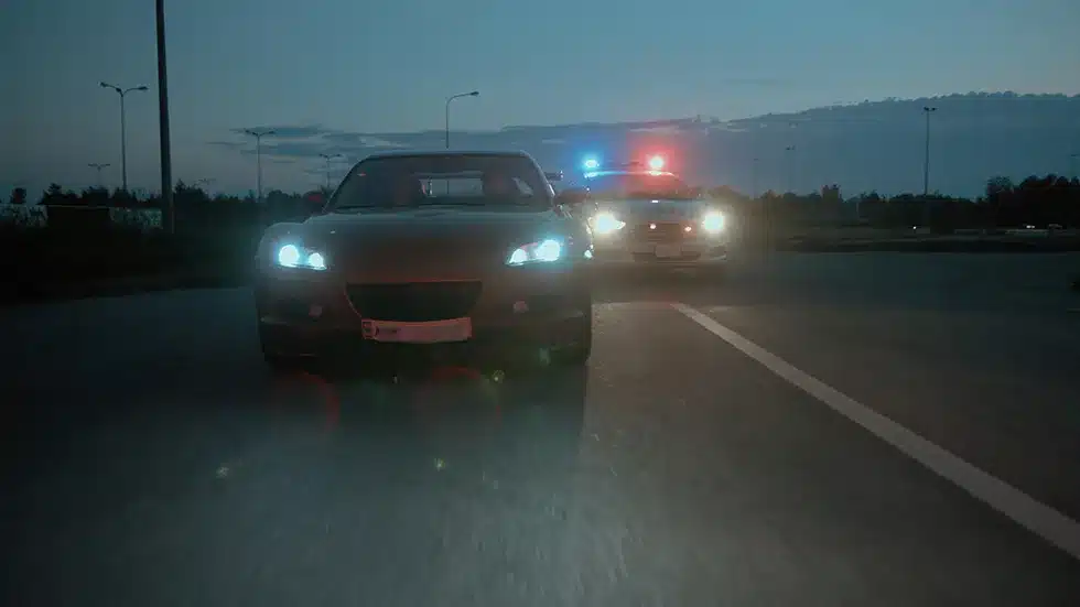 A drunk driver being followed by a cop car and thinking about calling a Harrisburg DUI defense lawyer.