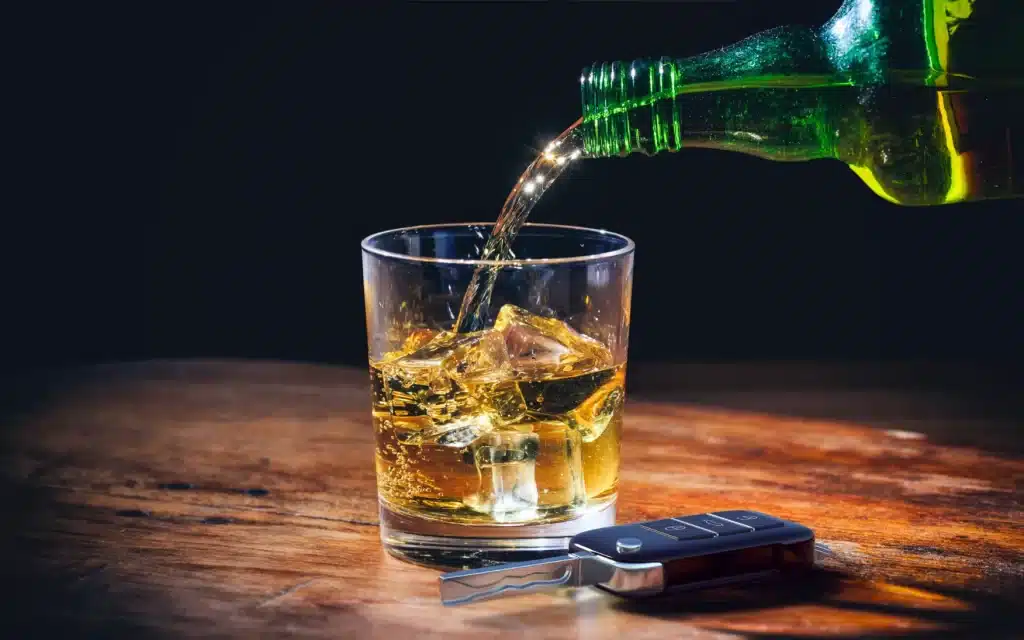 Pouring a drink into a glass with keys.