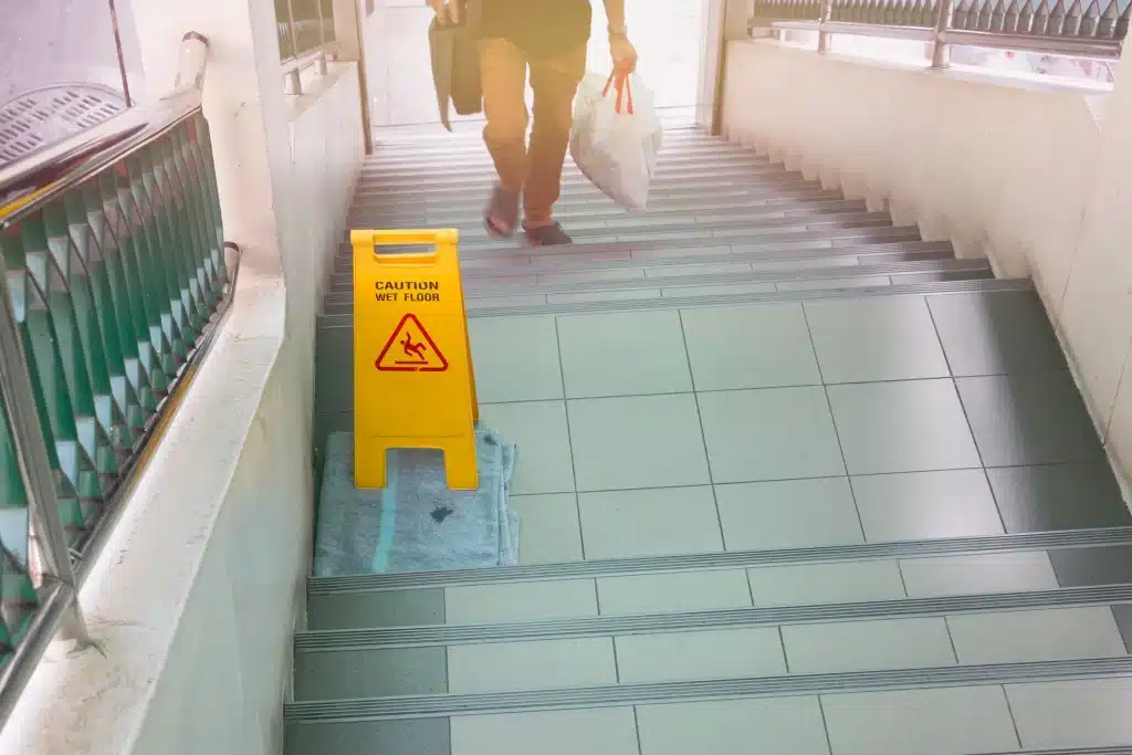 A wet floor sign on stairs.