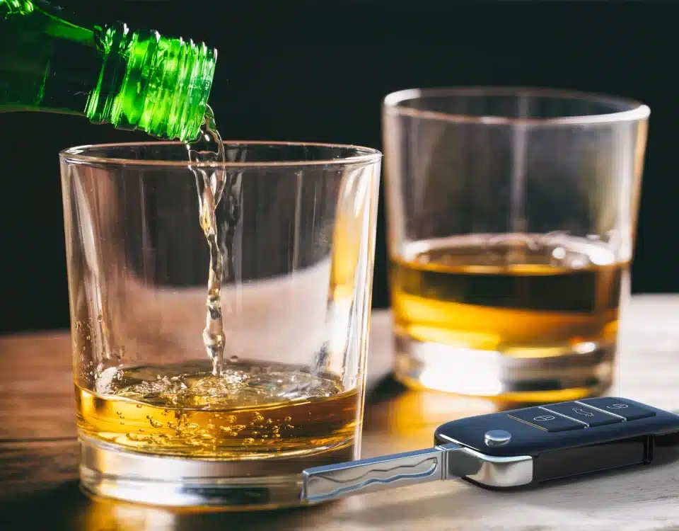 Pouring beer into a glass next to car keys.