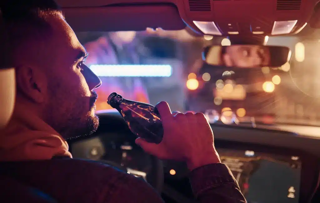 A person drinking while behind the wheel.