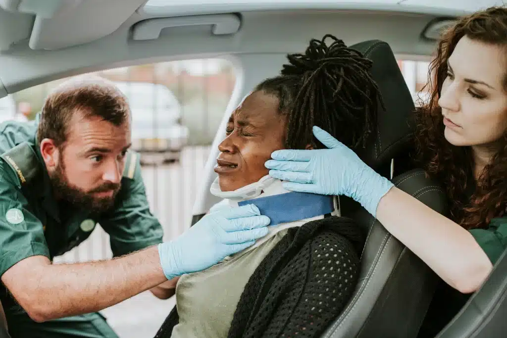 A woman being put in a neck brace after a car accident.
