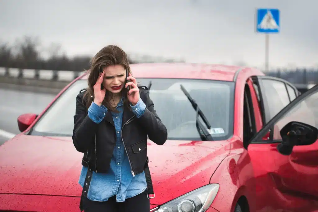 A women on a cellphone after being in a car accident.